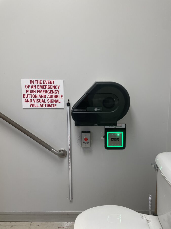 Accessible washroom with touchless door actuator, emergency call button and grab bar